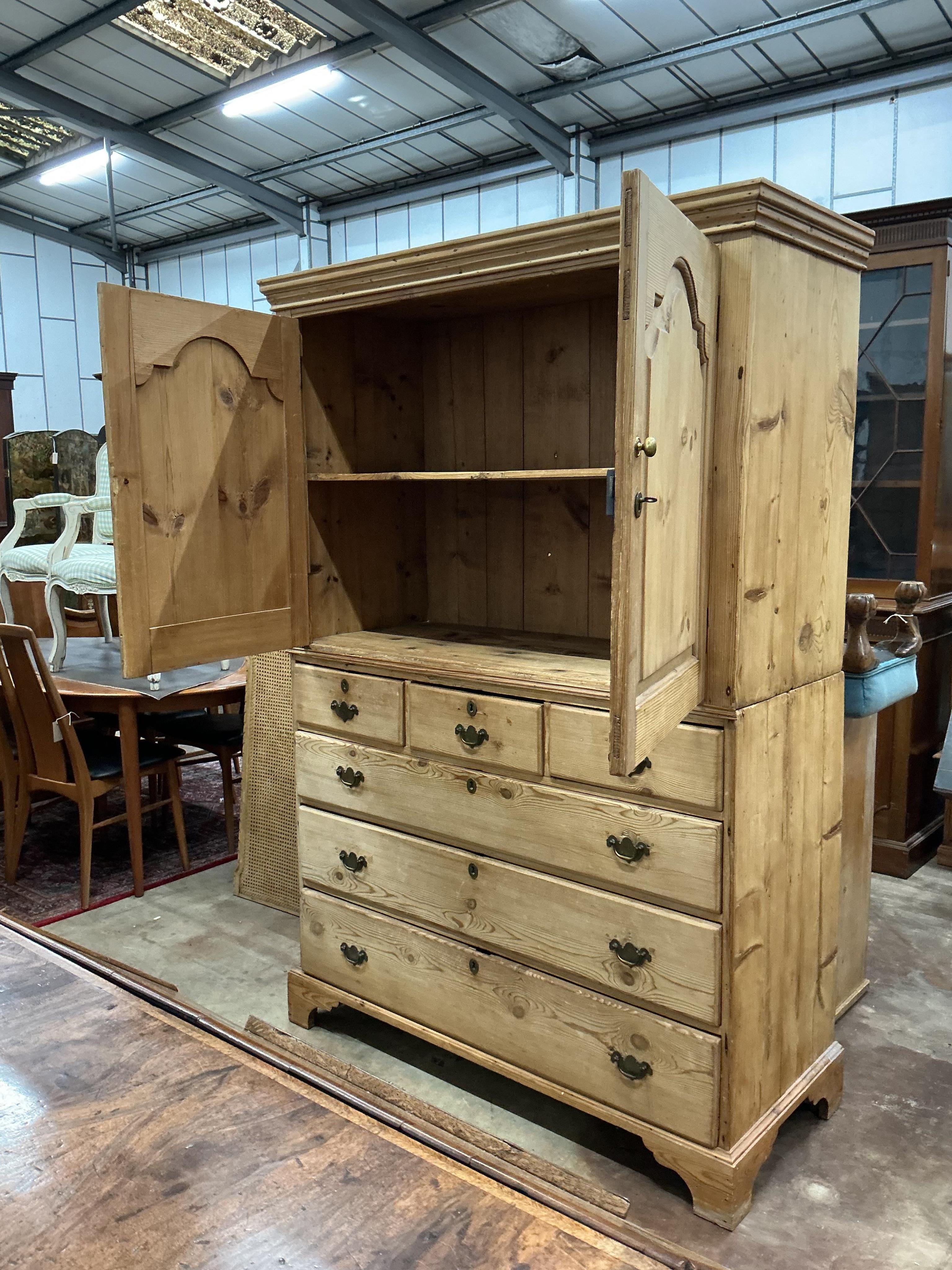 An early 19th century pine two part press cupboard, width 125cm, depth 54cm, height 191cm